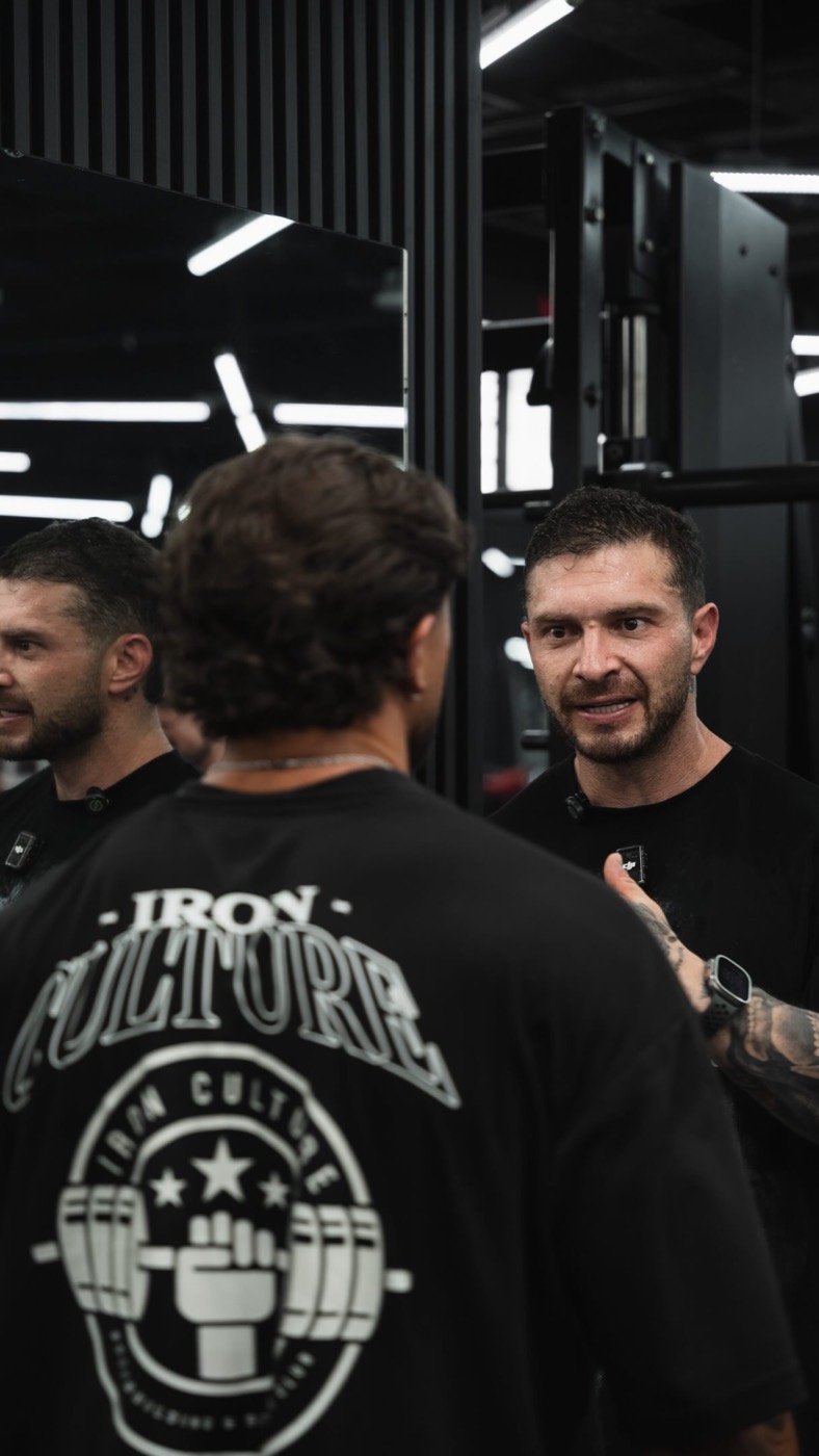 Head coach de Iron Culture conversando con un atleta en el gimnasio